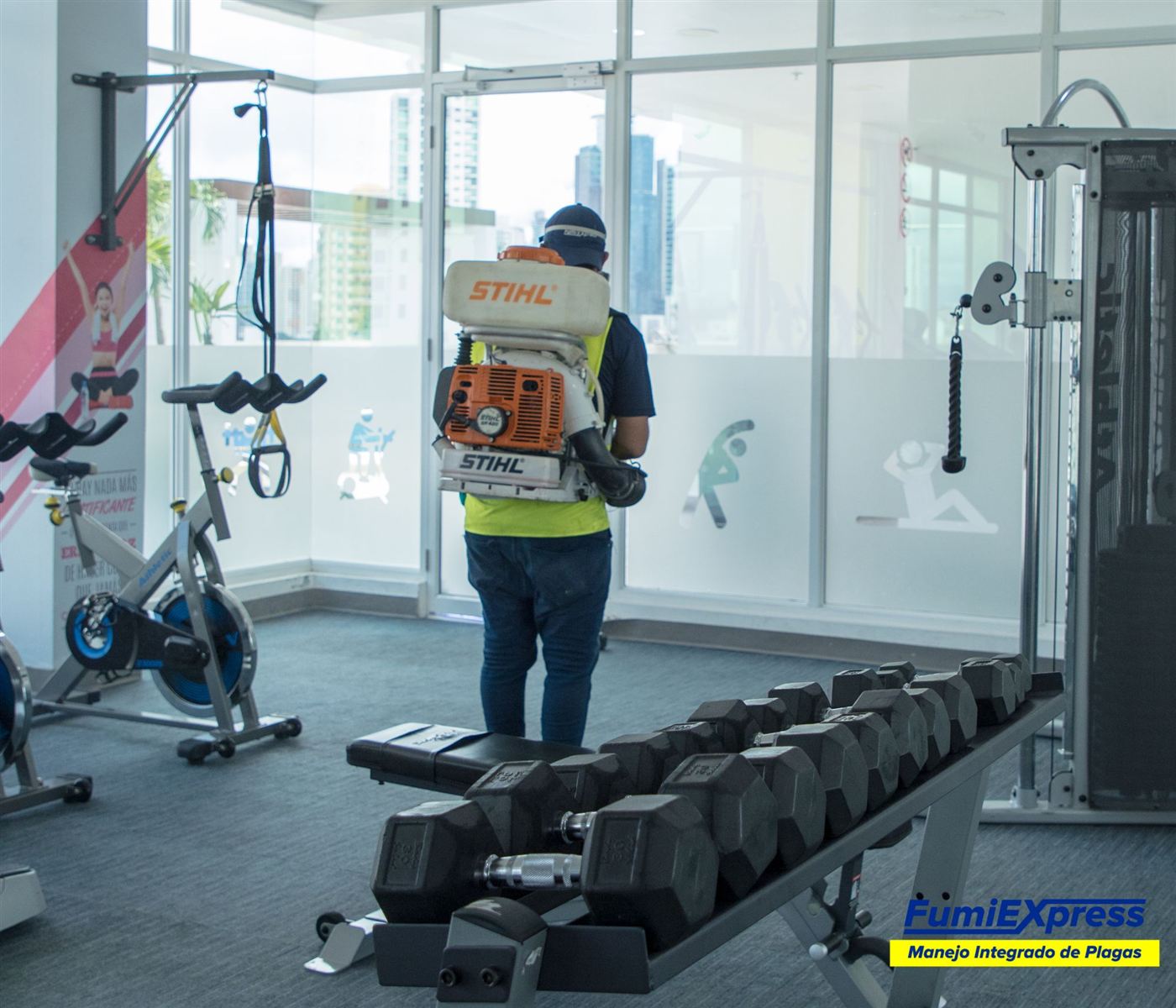 Técnico de Fumi Express aplicando tratamiento en un gimnasio