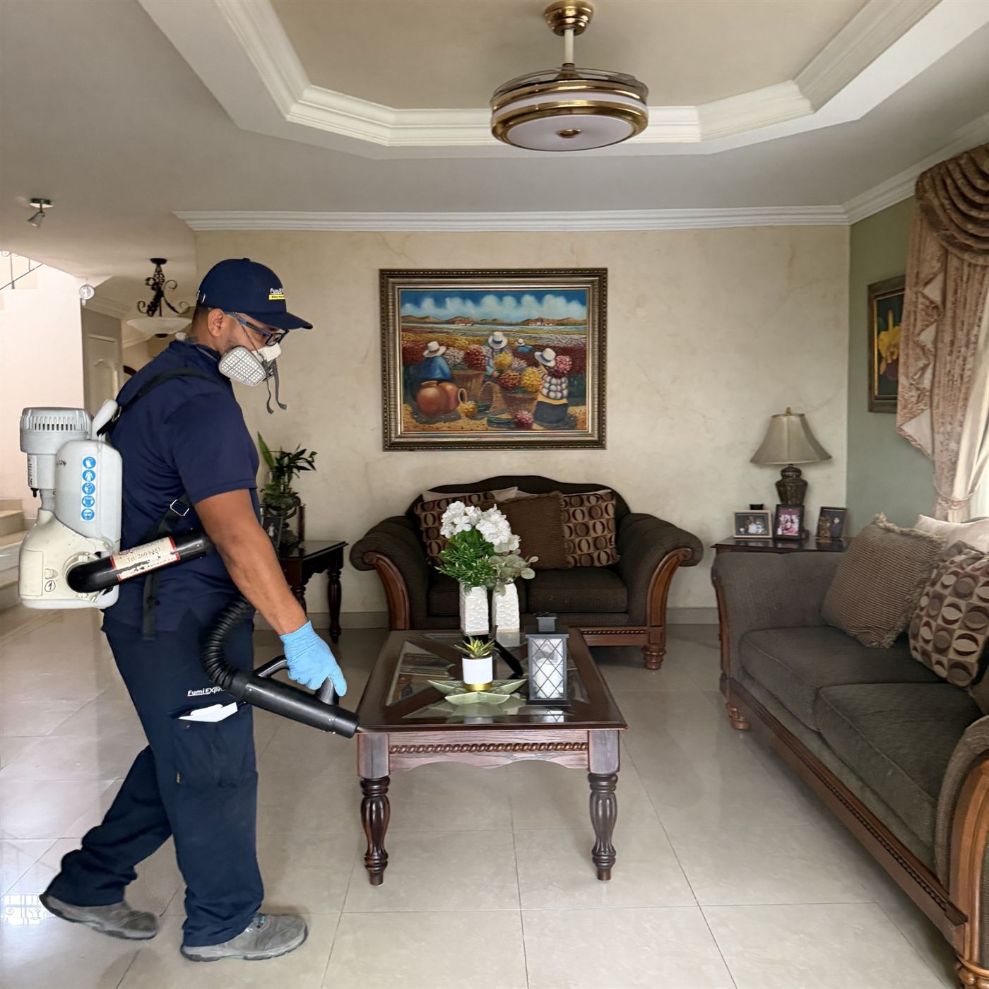 Técnico de Fumi Express aplicando tratamiento en la sala de una vivienda